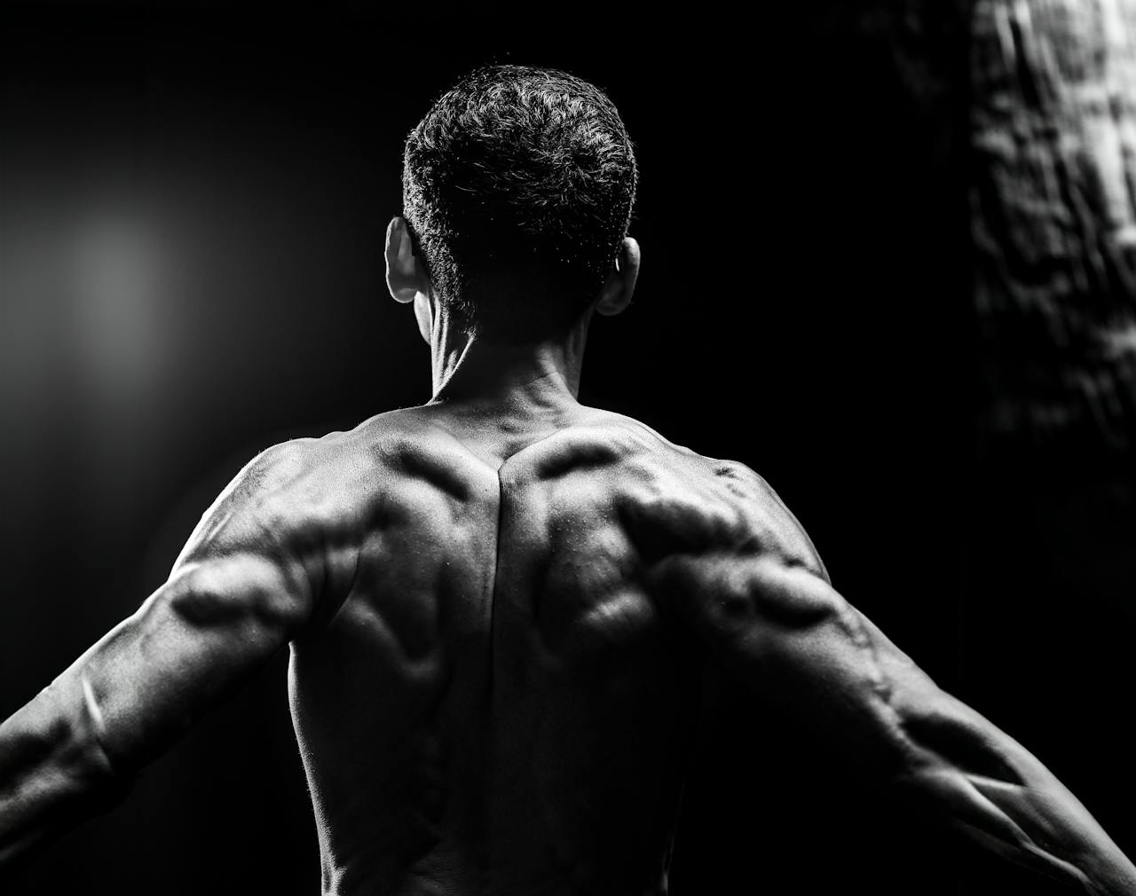 Dynamic black and white portrait highlighting muscular physique and body definition.